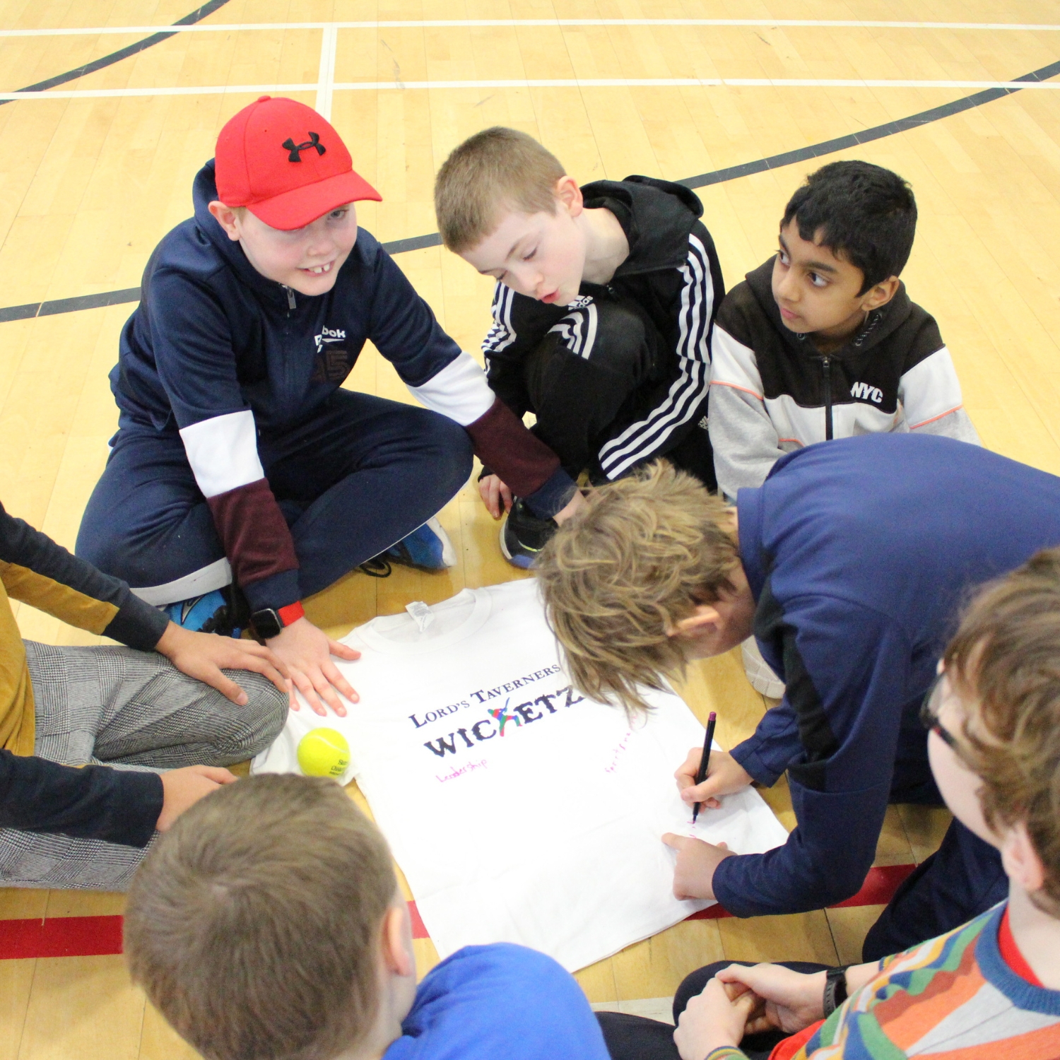 a group of boys designing a Wicketz t-shirt with their team values