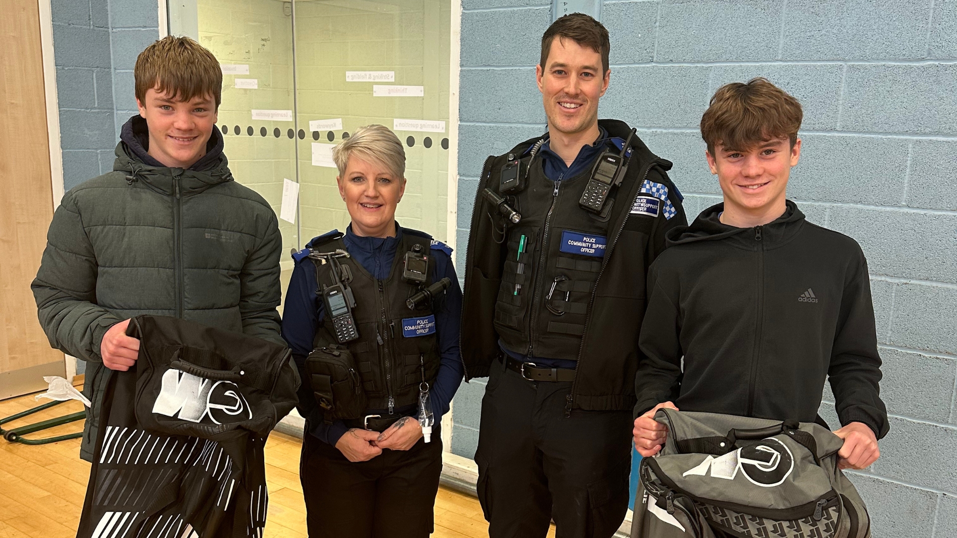 two boys receiving prizes from police community support officers